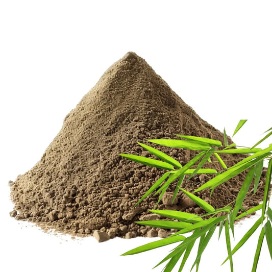 Heaped pile of bamboo leaf powder with fresh green bamboo leaves on a white background - WowNutri