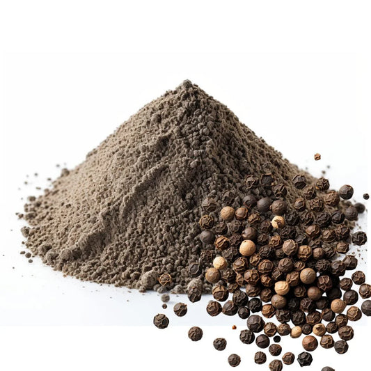 Heaped pile of finely ground Black Pepper powder with scattered whole Black Peppercorns on a white background - WowNutri